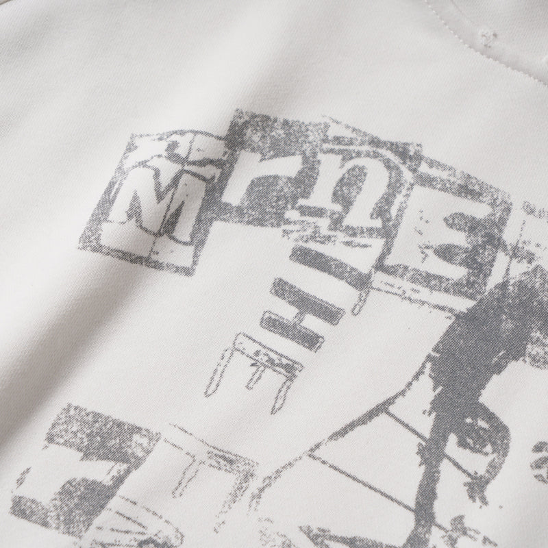 Close-up of graphic letters on white hoodie, showing distressed print texture