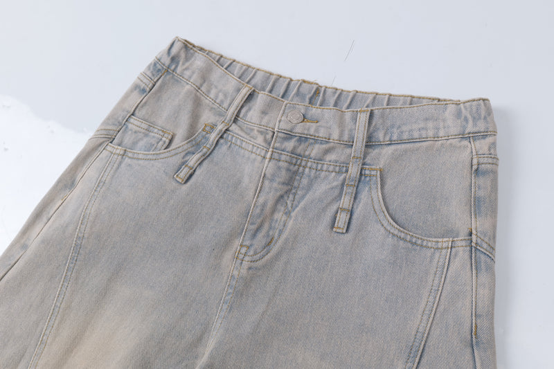 Close-up of front waistband on light wash jeans with button closure, belt loops, and pockets