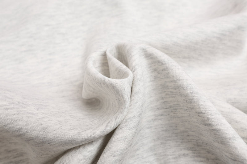 Close-up of light gray hoodie fabric texture with soft folds