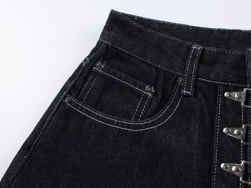 Close-up of the front left pocket and waistband on dark wash denim shorts