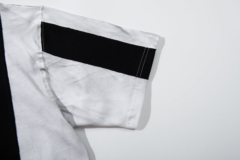 Close-up of a white striped football jersey sleeve with a bold black band and stitched hem on a clean background
