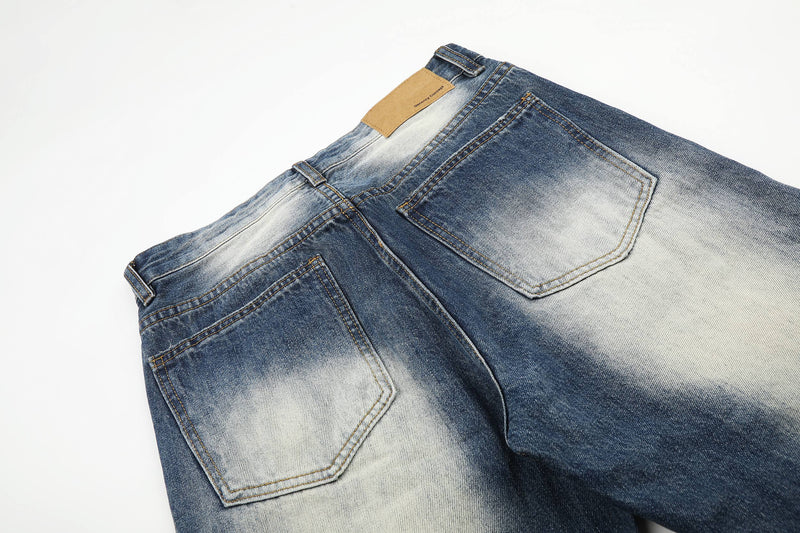 Close-up of back pockets on faded blue jeans with light wash panels
