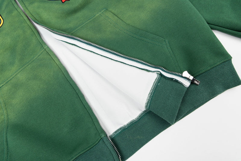 Close-up of green zip-up hoodie opening showing white inner lining and zipper