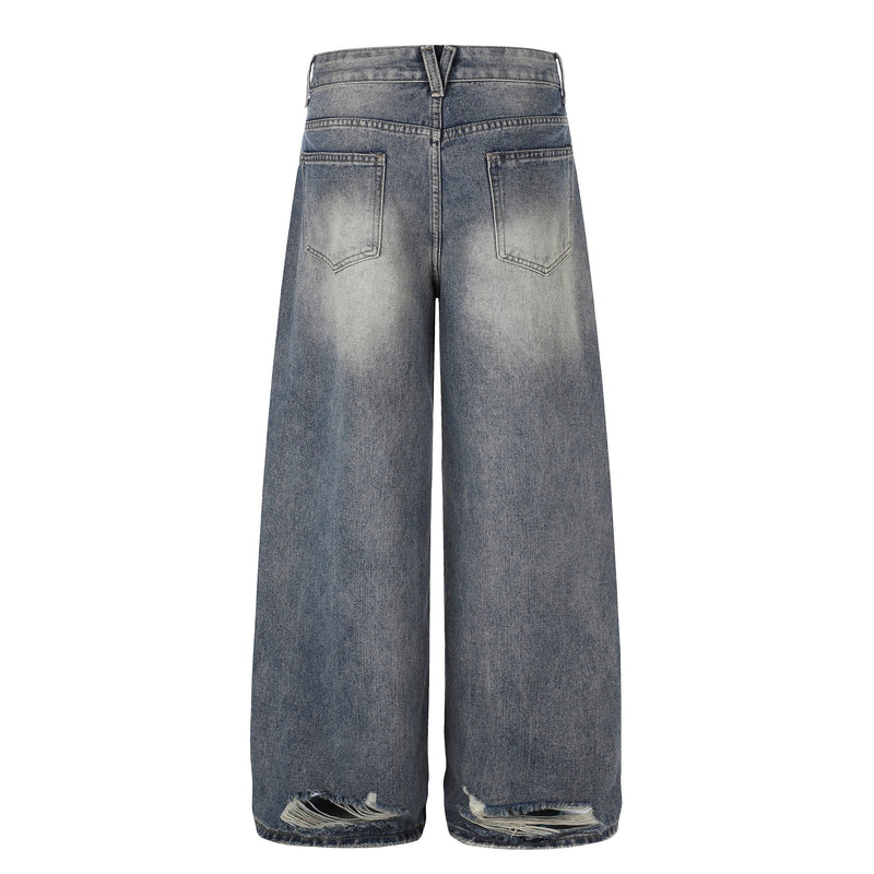 Back view of washed wide-leg jeans with patch pockets and frayed hem rips