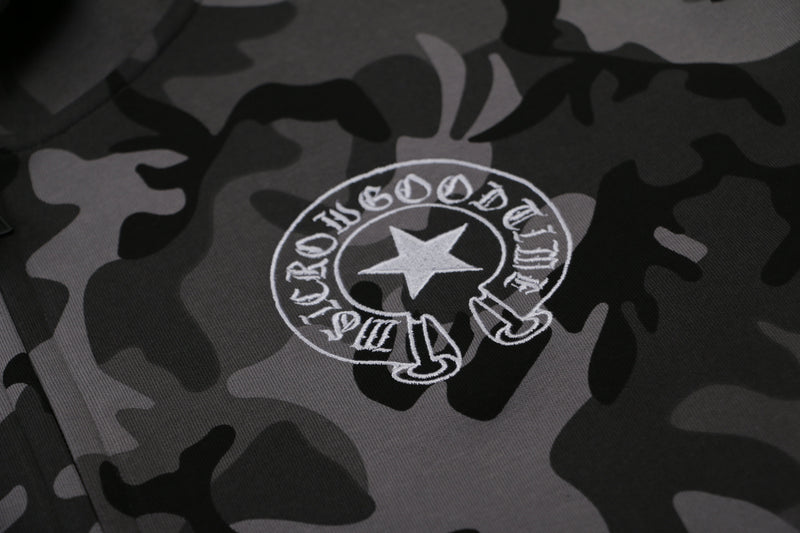 Close-up of white chest logo on gray camo hoodie fabric