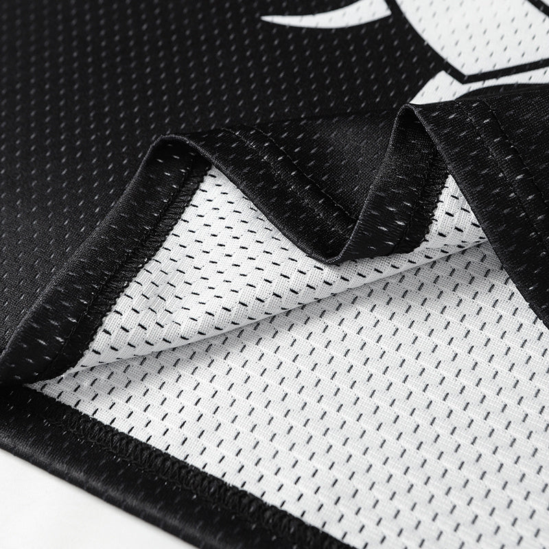 Close-up of black and white mesh football jersey fabric with stitched trim and breathable athletic texture