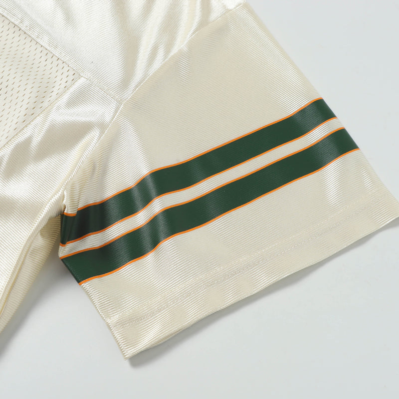 Cream retro football jersey sleeve with dark green and orange varsity stripes on textured fabric
