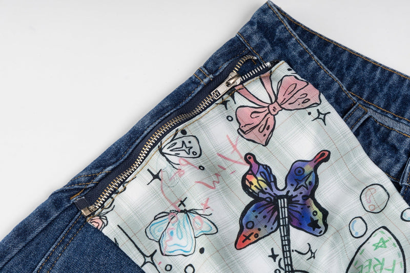 Close-up of blue jeans pocket opening with zipper trim and butterfly print fabric