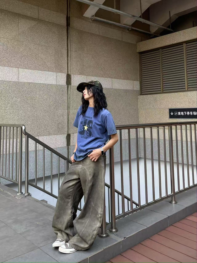 Side view of model wearing washed olive-brown wide-leg jeans with curved panel seams
