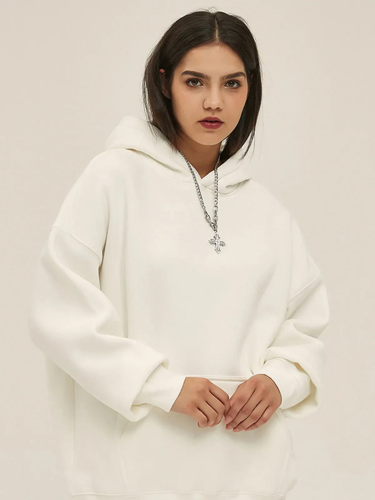 Woman wearing a Custom Anime Character White Hoodie - Personalized 350GSM 100% Cotton Pullover and a cross necklace, standing against a plain beige background.