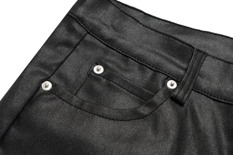 Close-up of front pocket stitching and metal rivets on black leather-effect pants