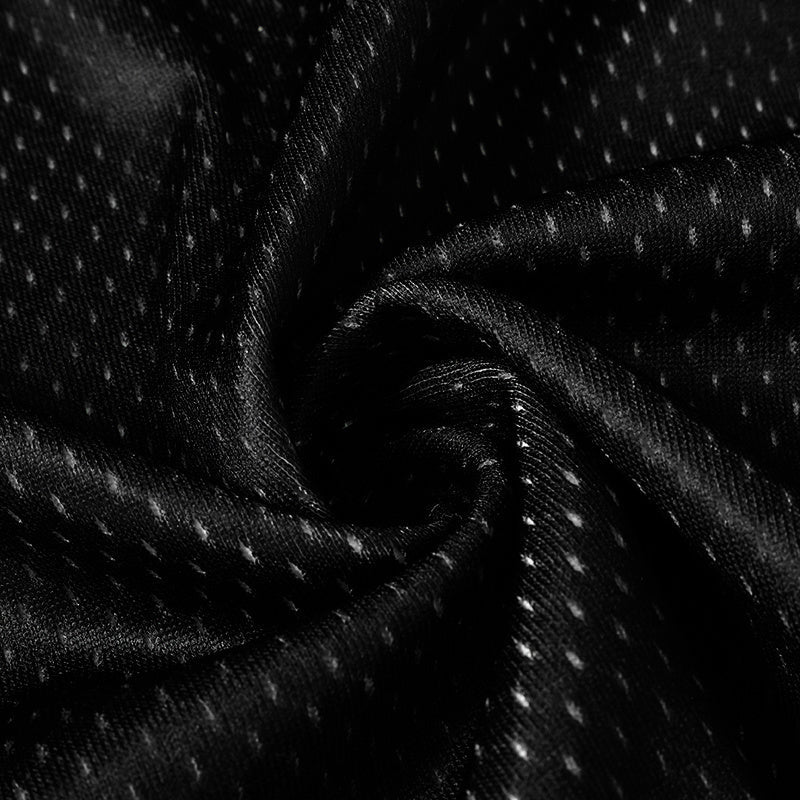 Close-up of black mesh jersey fabric with subtle white speckles and a dark gothic streetwear texture