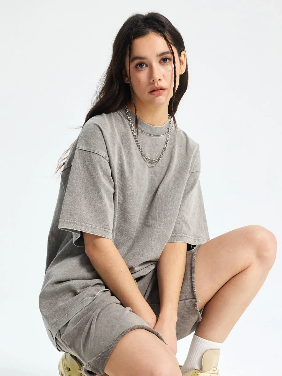 A woman wearing the Custom Anime Character Gray Washed T-Shirt - Personalized Anime Style Tee and matching shorts sits on a stool against a plain background.