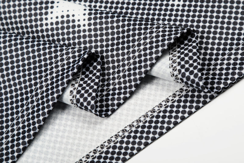 Black-and-white polka dot mesh jersey fabric with visible stitched seams and folded streetwear top detail
