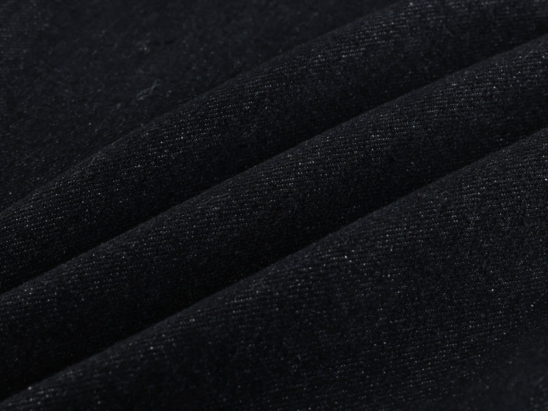 Close-up of black denim fabric texture with subtle twill weave