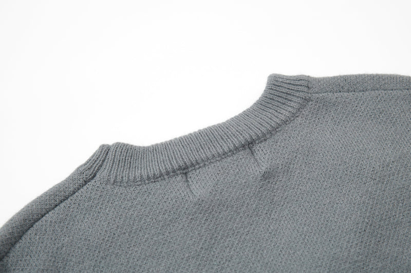 Gray knit sweater close-up of ribbed collar seam and shoulder