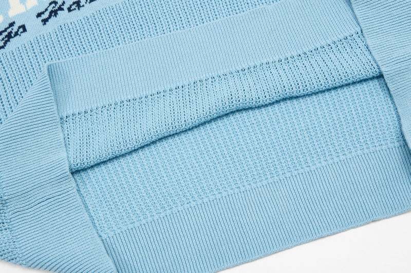 Light blue varsity knit polo with textured stripes and ribbed hem, featuring a collegiate streetwear look