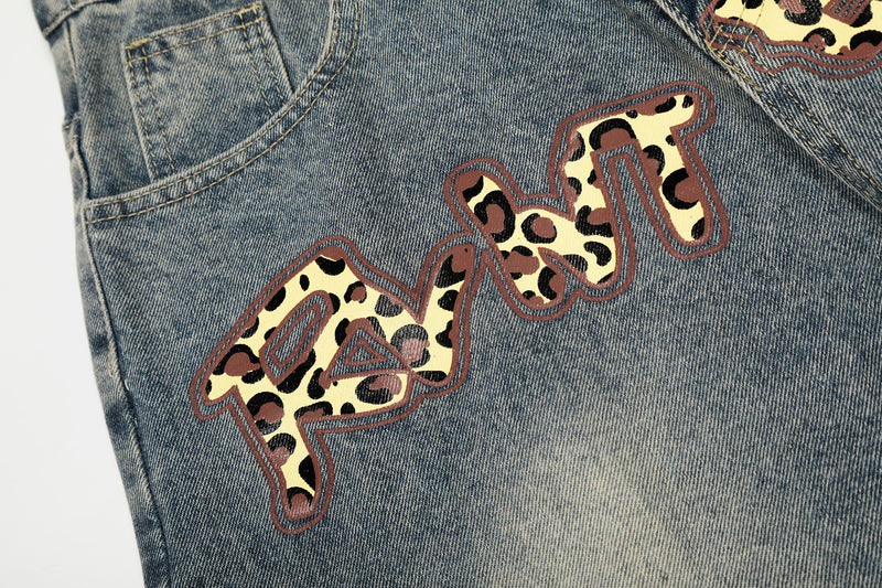 Close-up of leopard print word graphic on blue denim jeans