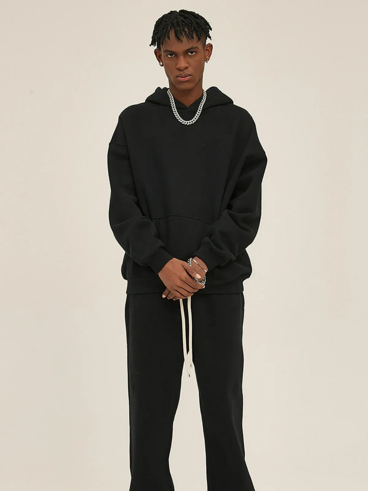 A person stands against a plain background wearing the Custom Anime Character Black Hoodie—Personalized 350GSM 100% Cotton Pullover—with black pants and a silver chain necklace, looking straight at the camera, inspired by anime character design.