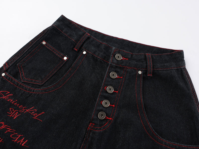 Close-up of front waistband with button fly, belt loops, red stitching, and front pocket