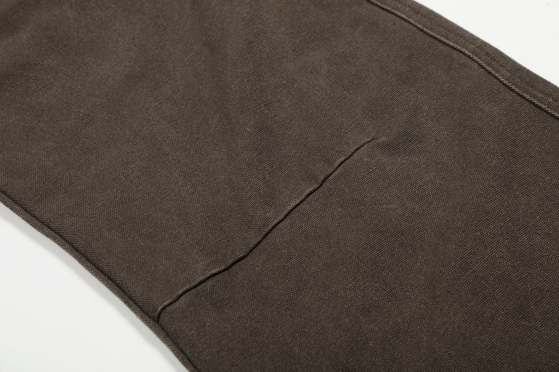 Close-up of brown pants leg panel with diagonal seam stitching