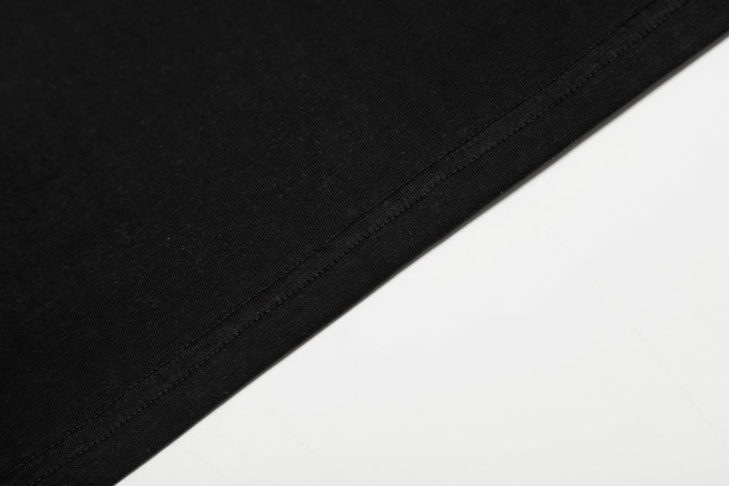 Close-up of black hem stitching on smooth knit shirt fabric