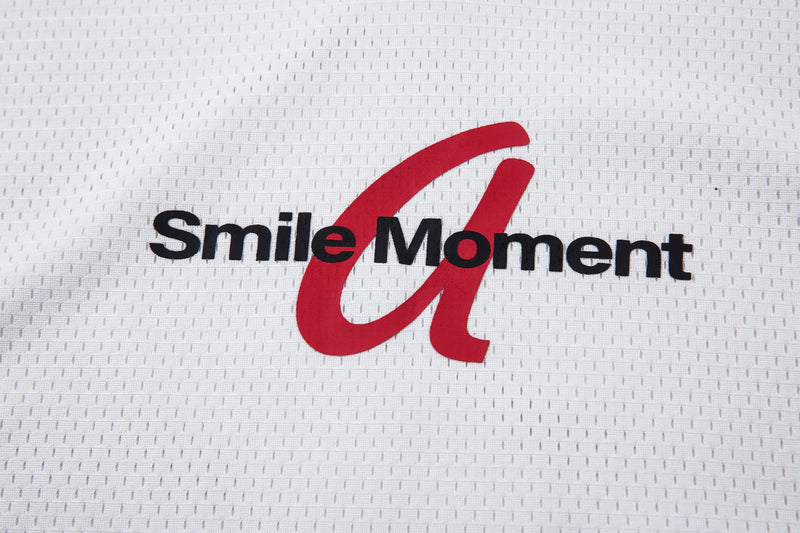 White mesh polo jersey with a bold red Smile Moment logo printed across the chest