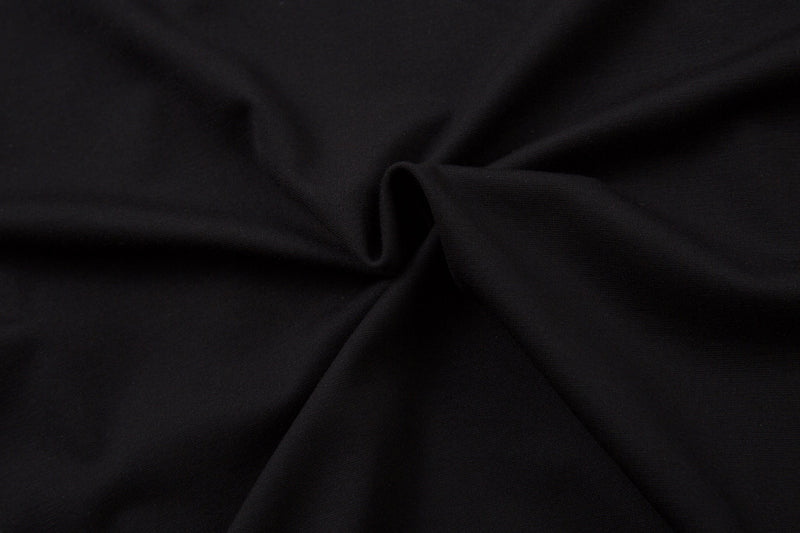 Close-up of black fabric texture and seam on the raglan top