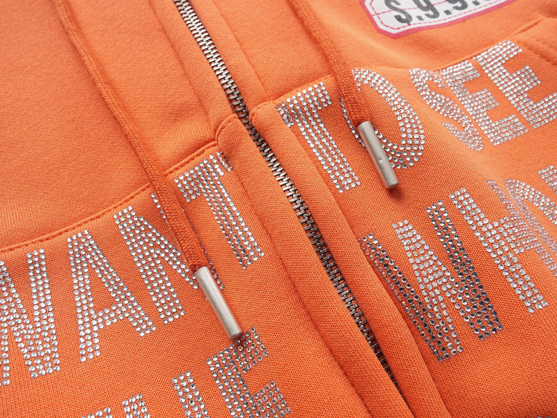 Close-up of orange hoodie rhinestone lettering across the front pocket
