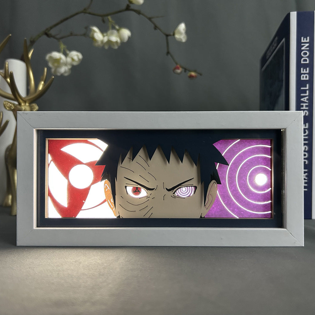 This Naruto Anime Light Box features a framed rectangular LED panel with a 3D effect of Obito Uchiha, showcasing his distinctive eyes and serious expression. With 16-color adjustable lights, it includes a decorative branch and book backdrop for added charm.