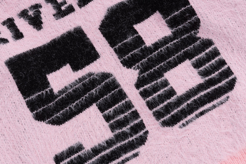Close-up of black 58 graphic on pink fuzzy knit sweater front