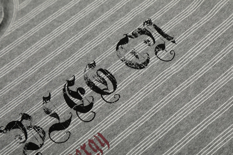 Close-up of black Gothic lettering on gray striped tee with red text below