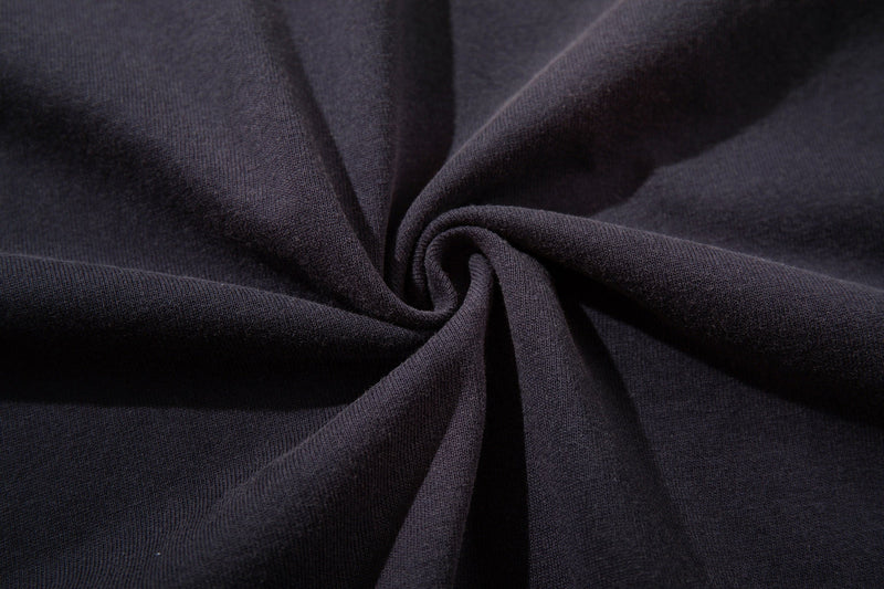Close-up of black washed cotton fabric with a soft textured drape, showing the vintage grunge tee material details