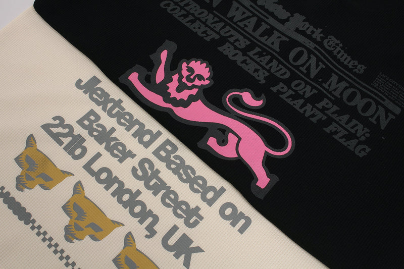 Black and cream waffle knit tee with vintage newspaper-style graphics and a pink leaping tiger print