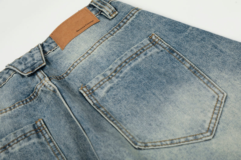 Close-up of back pocket and waistband label on faded blue denim pants
