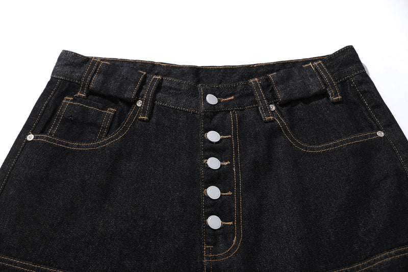 Close-up of black denim waistband and button fly with tan topstitching