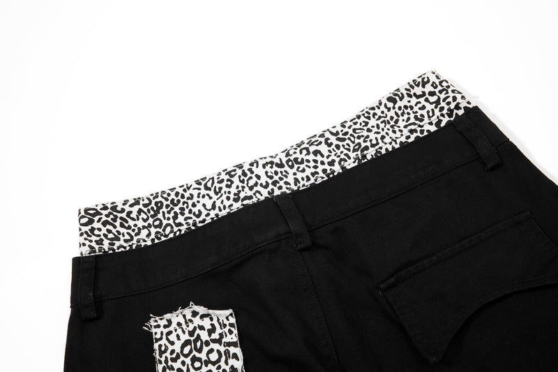 Close-up of black pants back waistband with leopard-print trim and belt loop detail