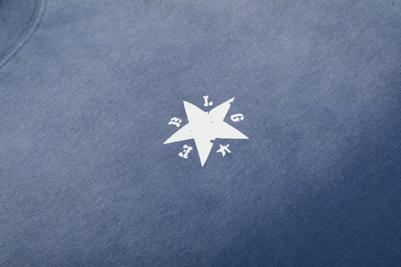 Close-up of blue gradient washed cotton tee with white star graphic on the back, showcasing the faded Seakoff design