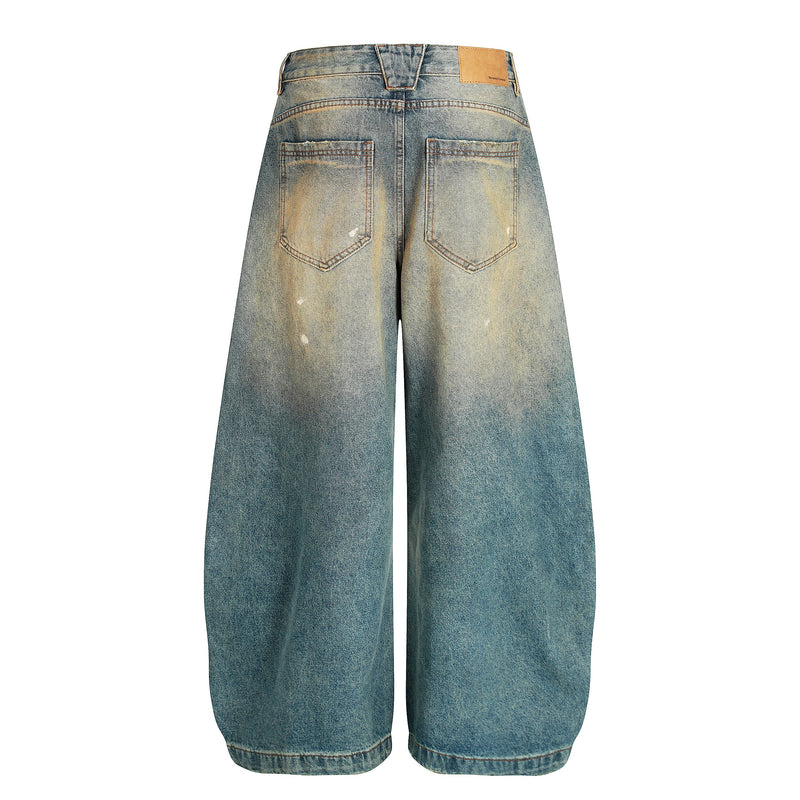 Back view of sun-faded wide-leg jeans with two patch pockets and light distressed wash