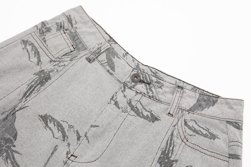 Close-up side view of the waistband and front pocket on abstract print jeans