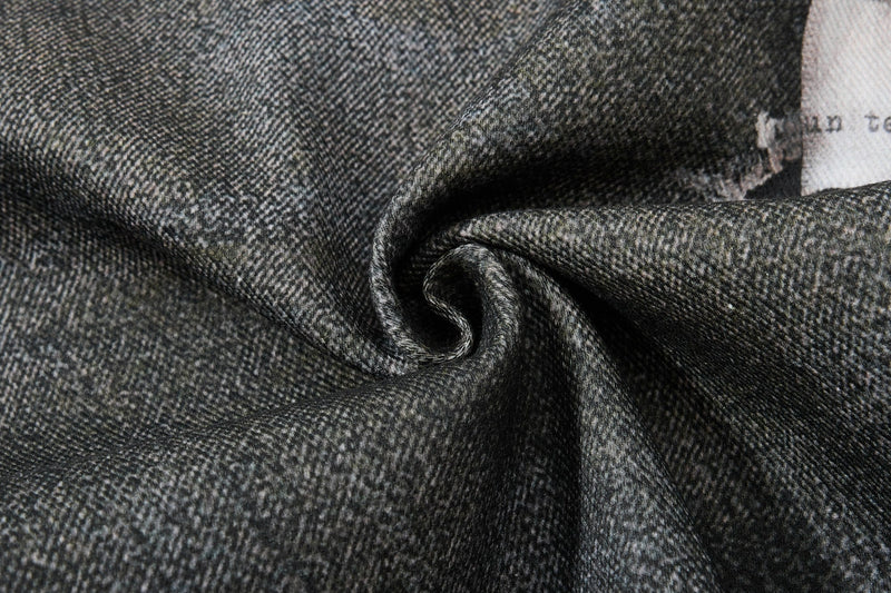 Close-up of black denim fabric texture with soft folds and twill weave