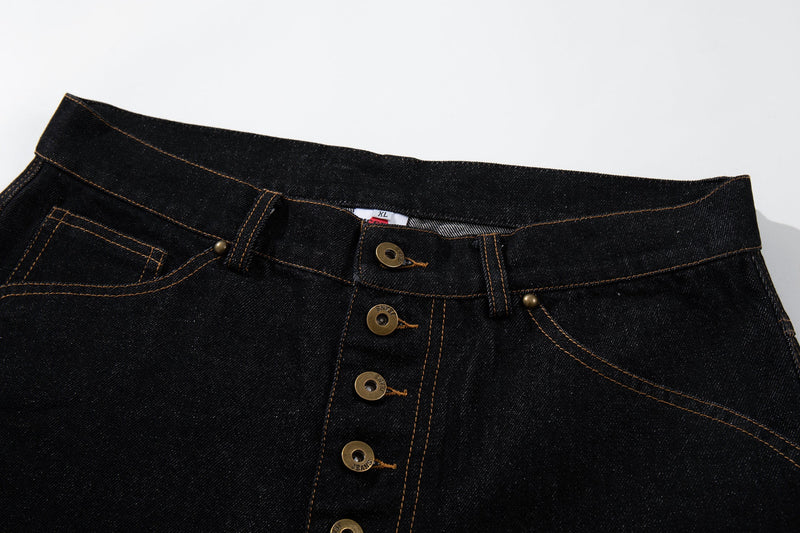 Close-up of the waistband and high-rise button fly on black denim pants