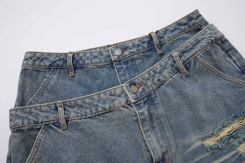 Close-up of layered blue denim waistbands with button details and faded wash