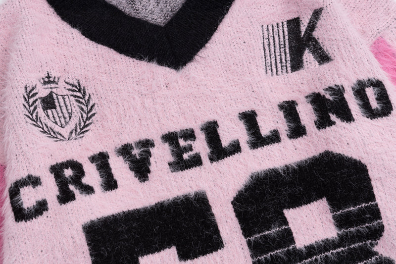 Close-up of pink fuzzy knit sweater front with crest, K graphic, and CRIVELLINO lettering
