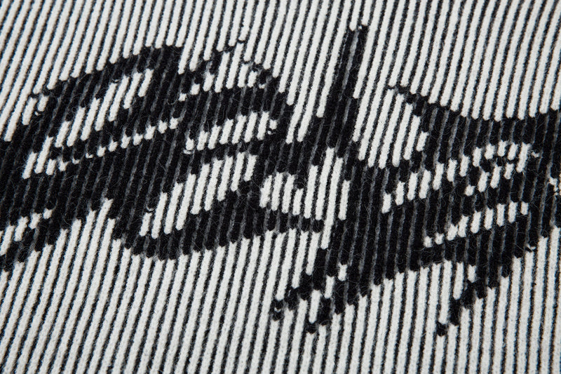 Close-up of lightning graphic on black ribbed knit sweater body