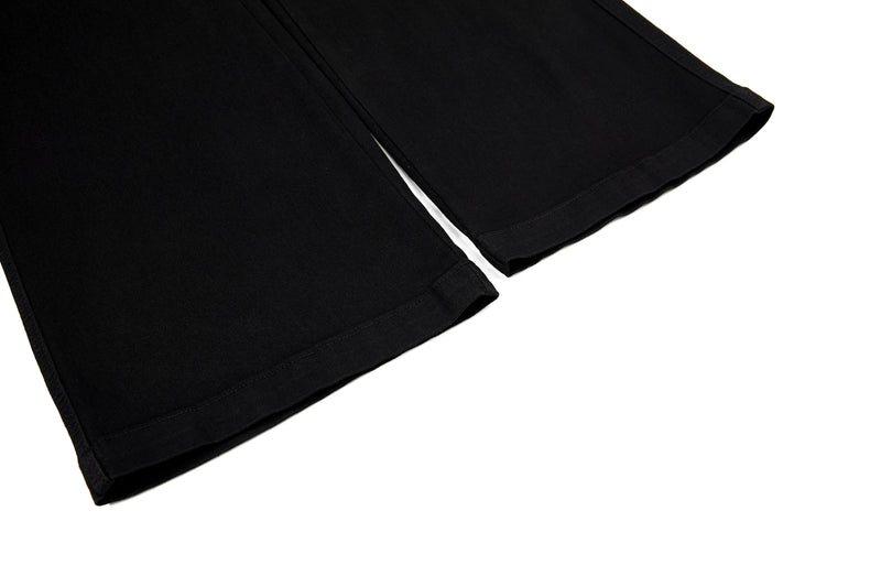 Bottom hem of black flared pants with wide leg opening
