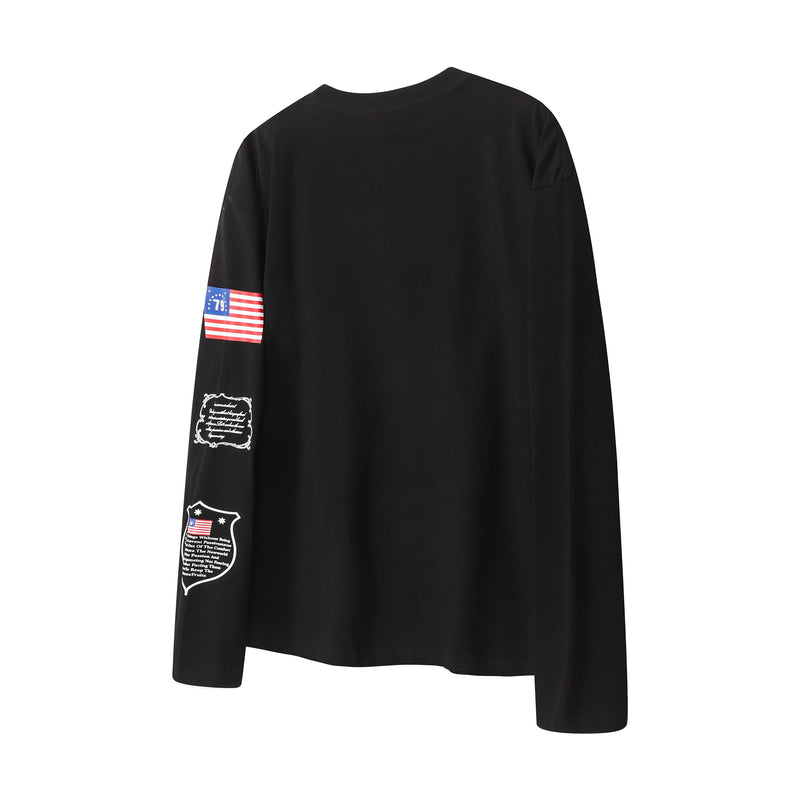 Back view of black long sleeve tee with flag graphic and small text print on one sleeve