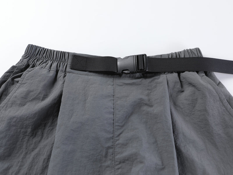 Close-up of gray shorts waistband with buckle belt and elastic gathering