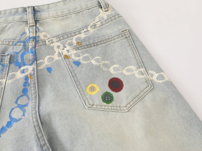 Close-up of back pocket on light wash denim pants with three painted button details