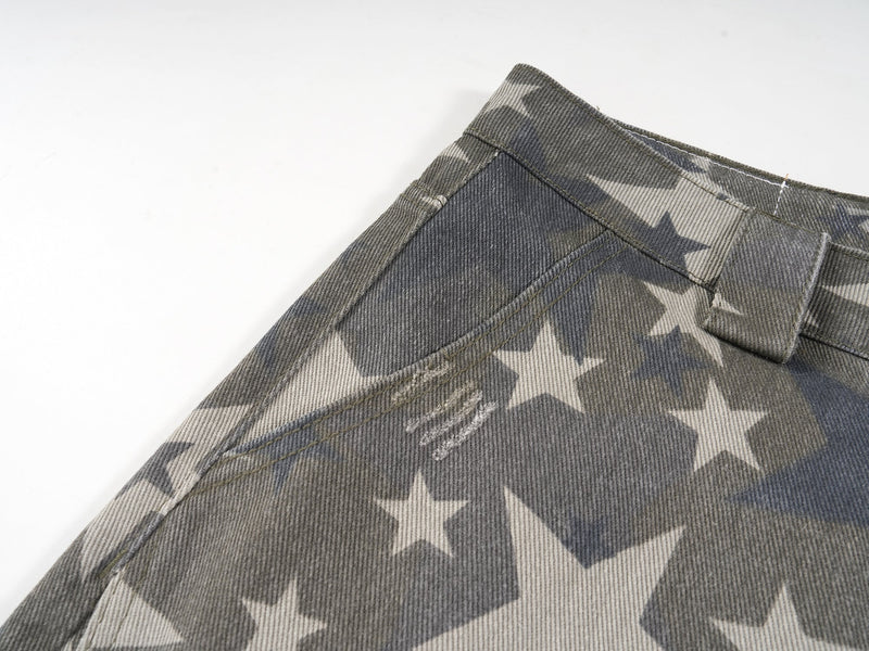 Close-up of front waistband and seam on gray star print denim pants